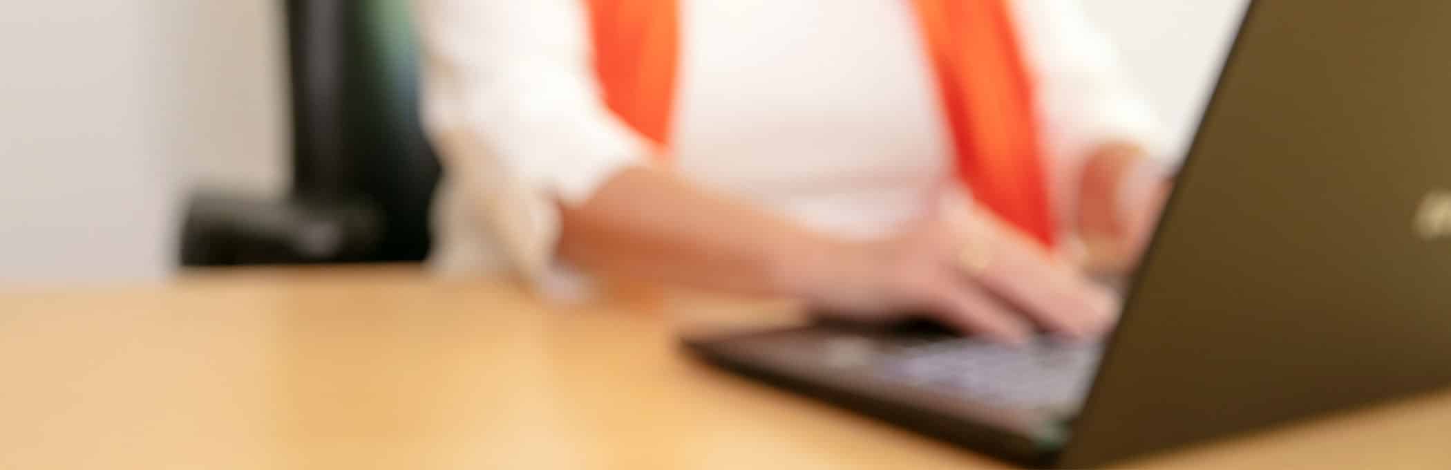 Frau Stuhlmacher, Fachanwältin für Sozialrecht, sitzt am Schreibtisch am PC.